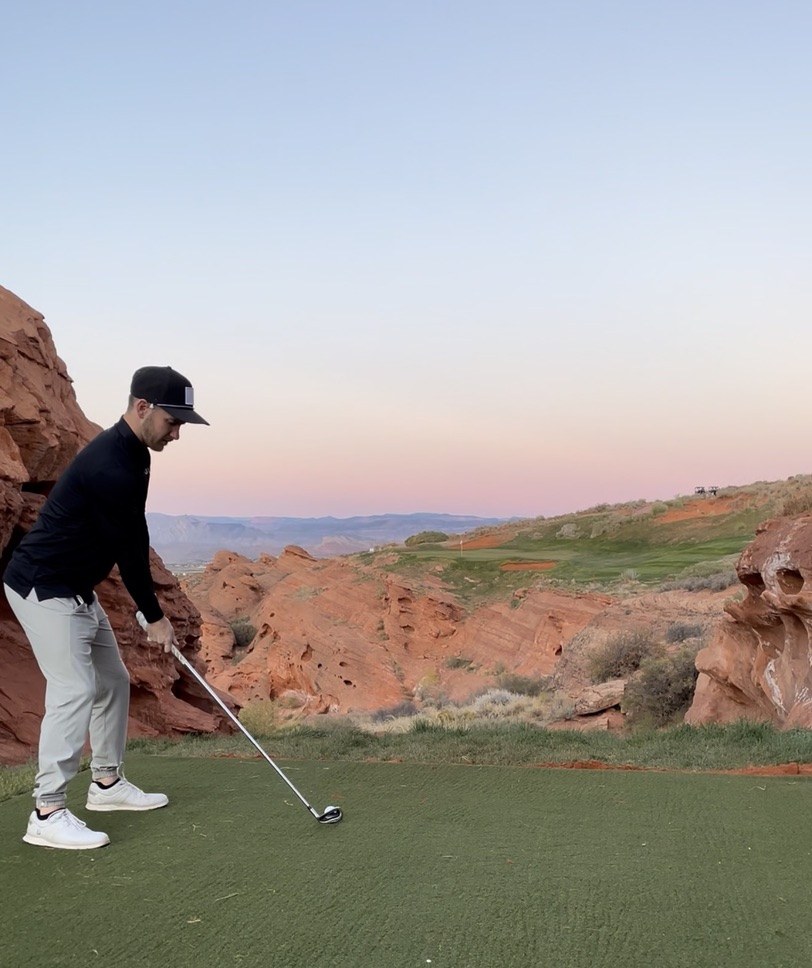 Coby Vandertoolen teeing off on a red-rock golf course in St. George, Utah